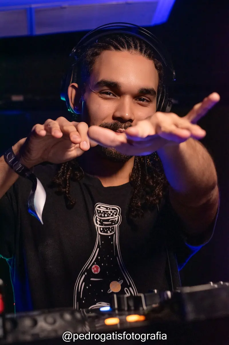 VASQS de headphone chamando a pista com as duas mãos